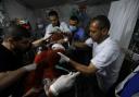Palestinian medics carry a child hurt in the Israeli bombardment of the Gaza Strip to the Kuwaiti Hospital in Rafah refugee camp (AP Photo/Ismael Abu Dayyah)