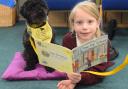 Six-year-old Scarlett reads to therapy dog Larry, also six, at the King's Park Infant School in Dereham