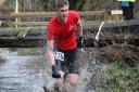 Dereham Road Runner Ash Gilbert wades in at the Reepham Cross Country Charity 10k. Picture: Andy Hawes