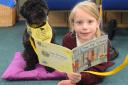 Six-year-old Scarlett reads to therapy dog Larry, also six, at the King's Park Infant School in Dereham