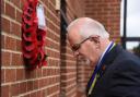 Dennis O'Callaghan, bows his head after laying the wreath at his father's memorial service in Dereham
