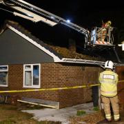 Fire fighters on the aerial platform putting out pockets of flames after a fire destroys a bungalow in Cathedral Drive, North Elmham. Picture: DENISE BRADLEY