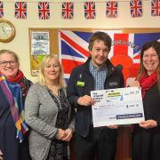 Nick Deree, store manager at Dereham's Original Factory Shop hands over the cheque to Dereham Cancer Care