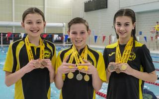 (LtR) Anastasia Wall, William Nutt, and Amalie Parnell, from the Dereham Otters swimming club, are celebrating after a successful showing at the Swim England Norfolk County Championships Swimming gala